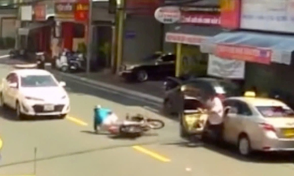 Nguoi phu nu di xe may thiet mang vi tai xe taxi mo cua bat ngo hinh anh