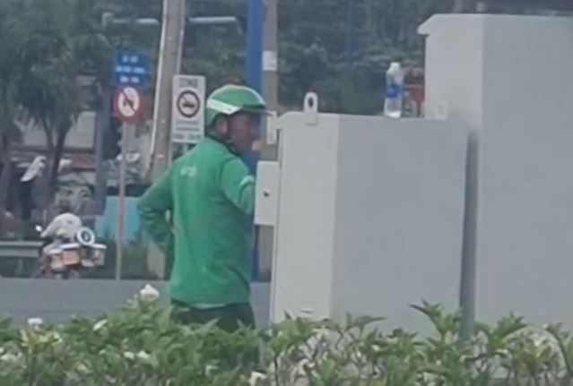 Nguoi mac do GrabBike chinh tin hieu den giao thong o TP.HCM hinh anh