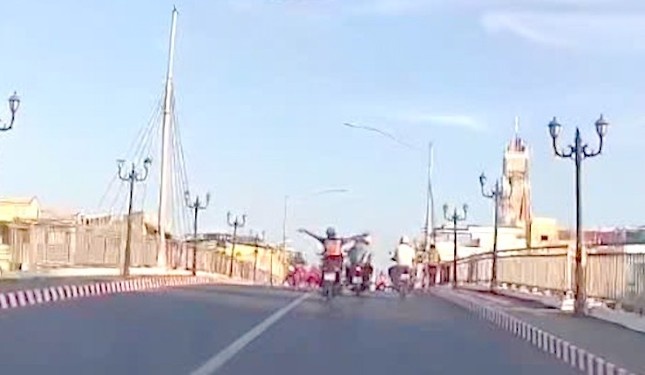 Nguoi dan ong lai xe may buong hai tay, nam tren yen o Bac Lieu hinh anh