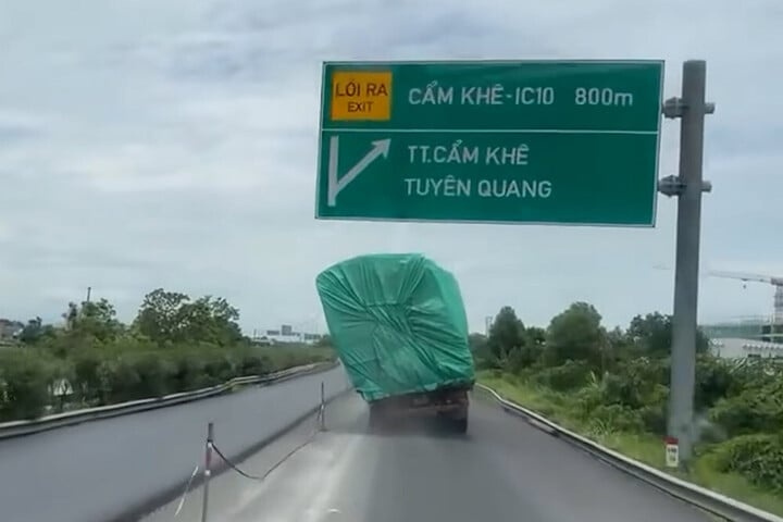 Xe tai cho thung hang nghieng han mot ben van phong nhanh tren cao toc hinh anh