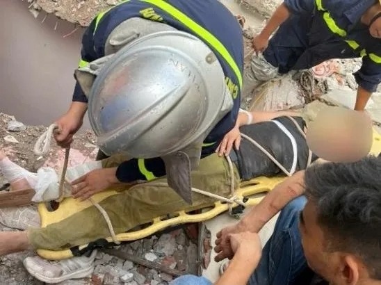 Canh sat giai cuu cong nhan bi khoi be tong do sap, de len nguoi hinh anh