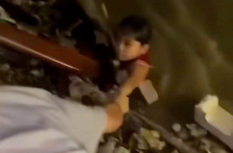 Thot tim giai cuu be trai bam tam go muc o chan cau Rong hinh anh