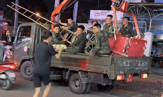 Chang trai TP.HCM tang trai cay cho bo doi di qua duong gay bao mang hinh anh