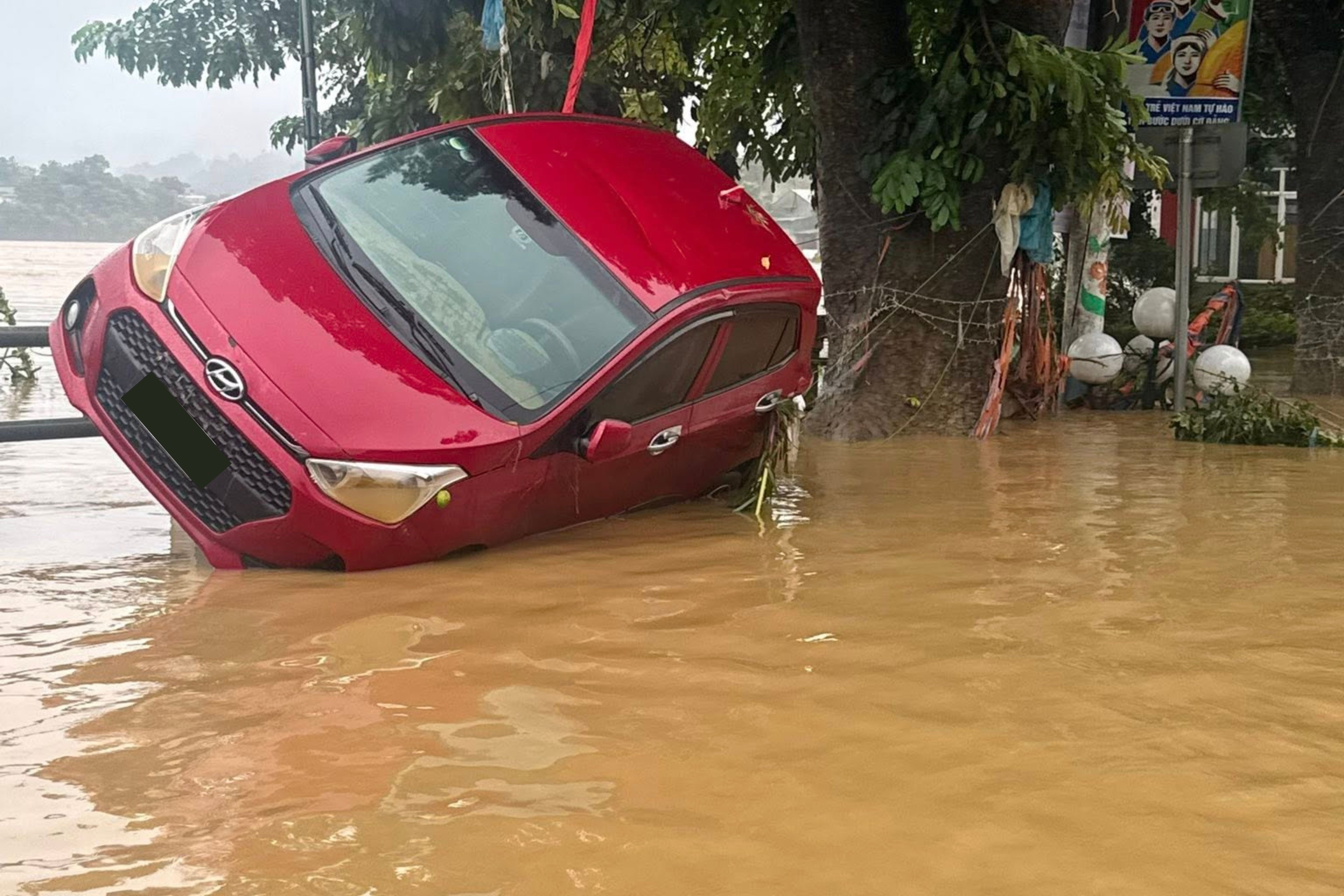 Hanh dong dut khoat cua 3 co chau 'cuu' oto nguoi la sap bi lu cuon di hinh anh