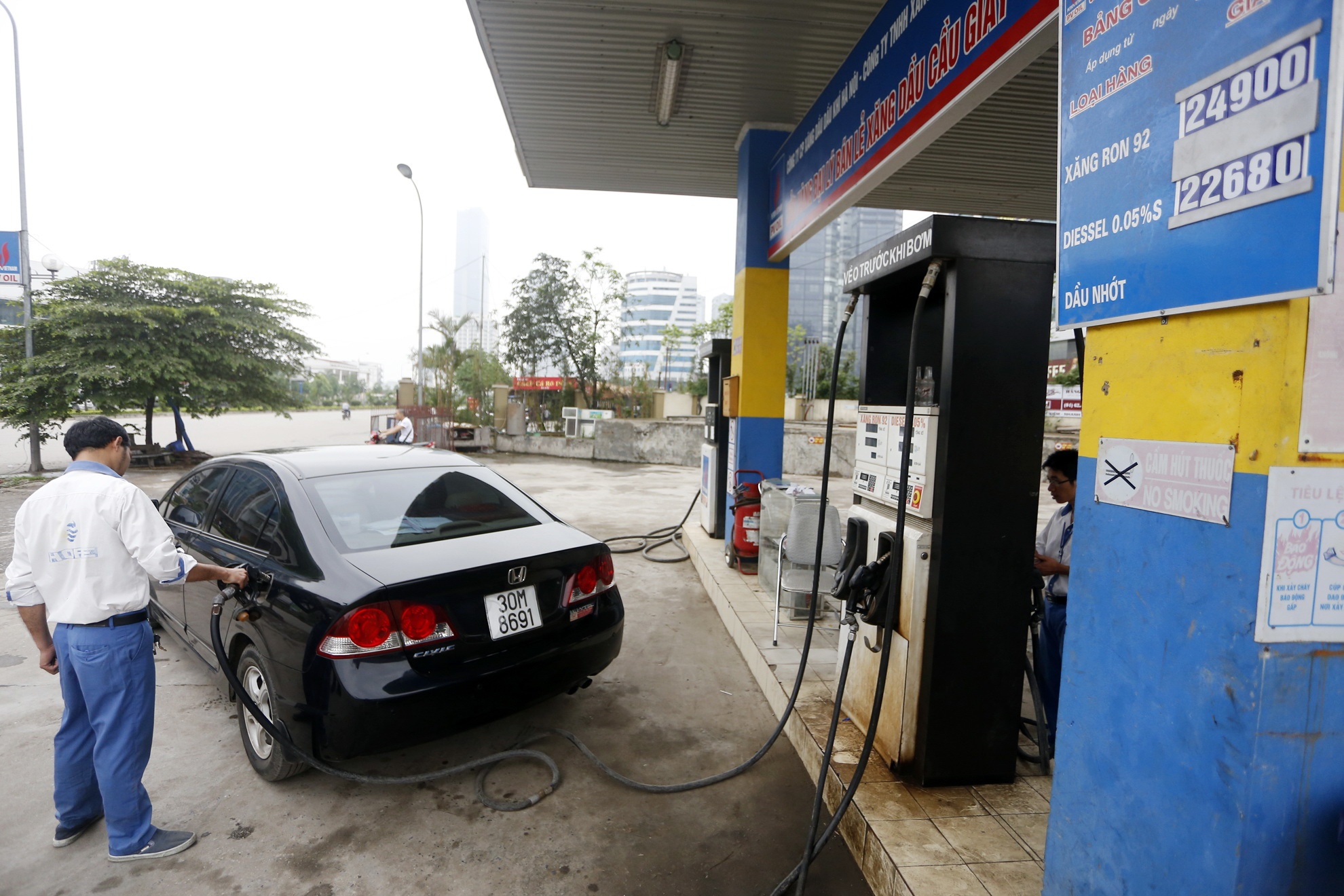 Khách hàng đổ xăng theo giá mới đầu giờ chiều nay trên đường Mễ Trì kéo dài (Hà Nội).  Ảnh: Lê Hiếu.