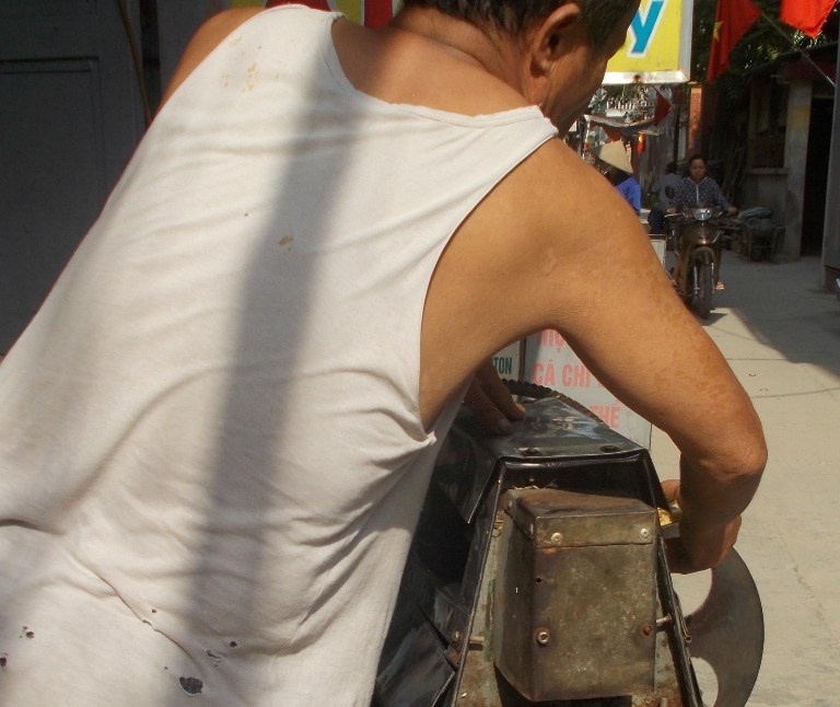 Người đàn ông này vừa dóc mía với bàn tay đầy bụi bẩn tiếp tục ép nước mía.