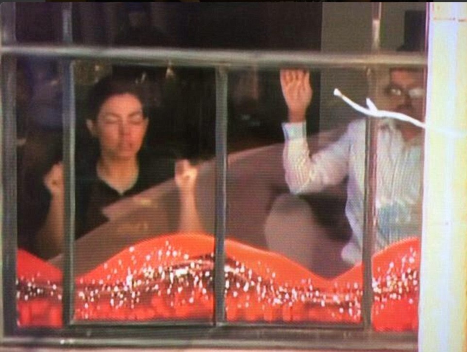 Con tin hoảng sợ khi đứng trước cửa sổ theo yêu cầu của tay súng. Ảnh: Daily Mail.