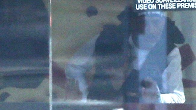 Tay súng đang kiểm soát một con tin trong quán cafe Lindt. Ảnh: News Corp Australia