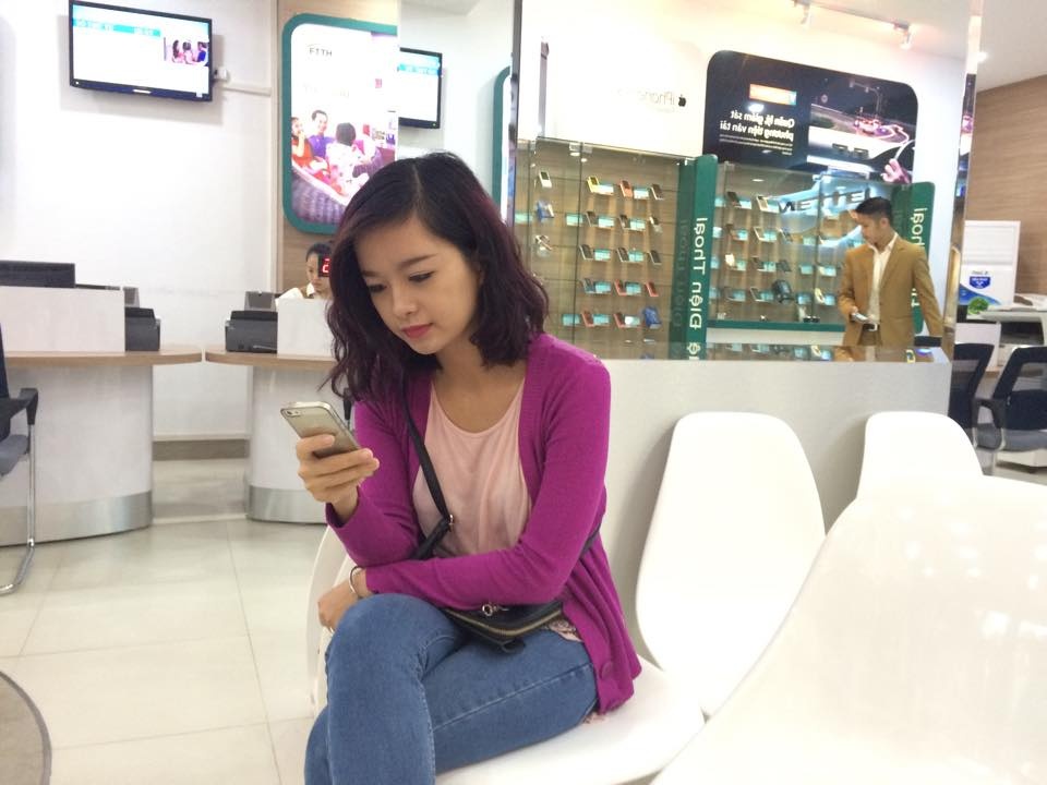 Chị Tạ Kim Ngân đang ngồi chờ làm thủ tục mua iPhone 6 của Viettel.