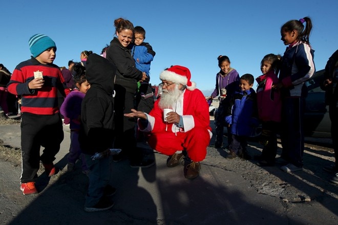 Nhân viên cứu hỏa tại thành phố Ciudad Juarez, Mexico cải trang thành ông già Noel để phát quà cho trẻ em. Ảnh: Reuters