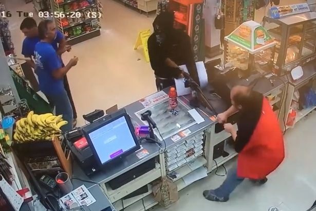 Nguoi ban hang dung cam giang sung cua ten cuop hinh anh