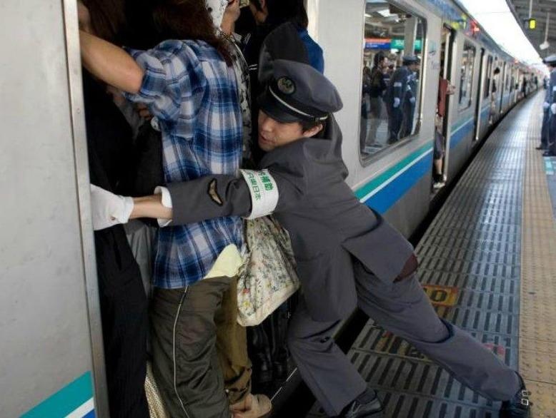 Canh 'len' nguoi len tau vao gio cao diem o Tokyo hinh anh