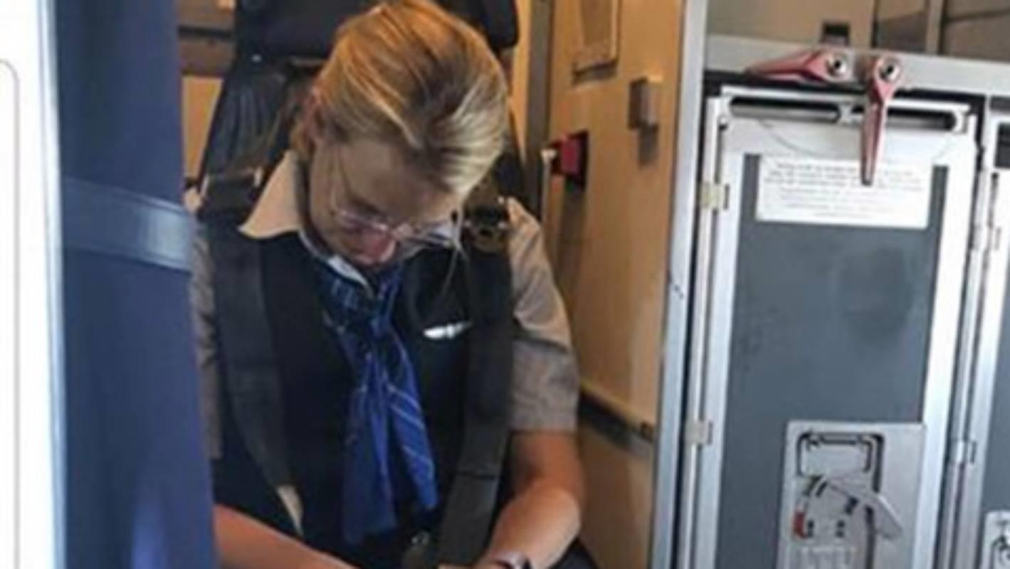 Nu tiep vien hang khong say xin tren chuyen bay hinh anh