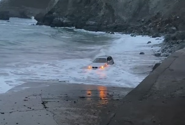 Xe BMW bi song lon keo troi xuong bien hinh anh