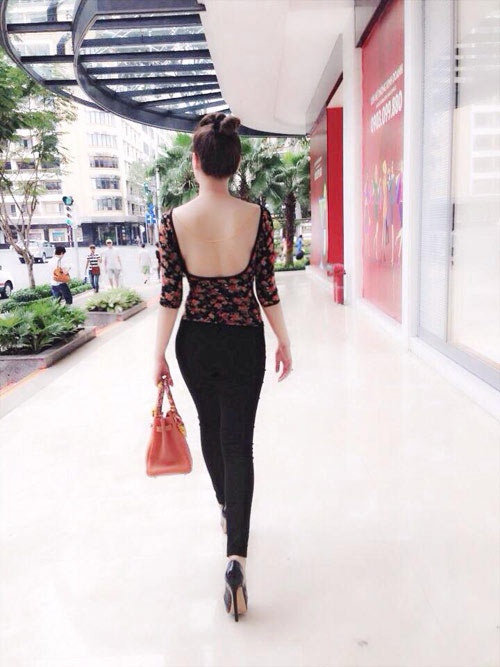 Quỳnh Thư khiến người đi đường không thể nào rời mắt với chiếc áo phô diễn gần như toàn bộ phần lưng. Cô khéo kết hợp rất lịch sự chiếc áo này với quần tregging.