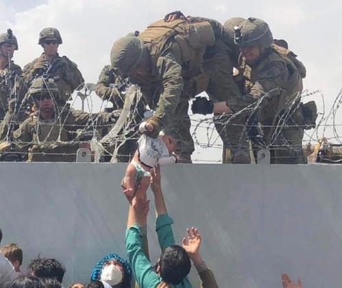 Tim thay em be duoc nang qua hang rao day thep gai o Kabul hinh anh