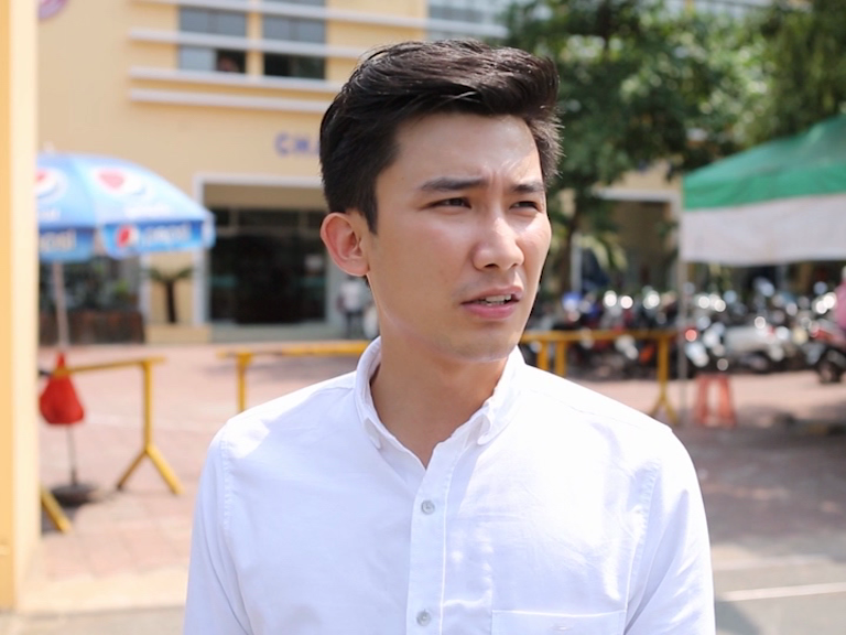 Chí Thiện nhăn nhó vì phải đứng ngoài trời nắng quá lâu mà không thấy Lan Vy.