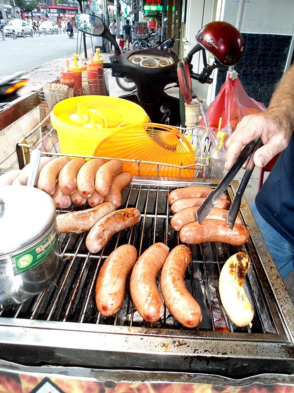 Theo ông, khách hàng vẫn thường hay mua bánh mì kẹp xúc xích hơn. Với mỗi cây xúc xích được bỏ vào trong lòng bánh mì, ông thu với giá 25.000 đồng.