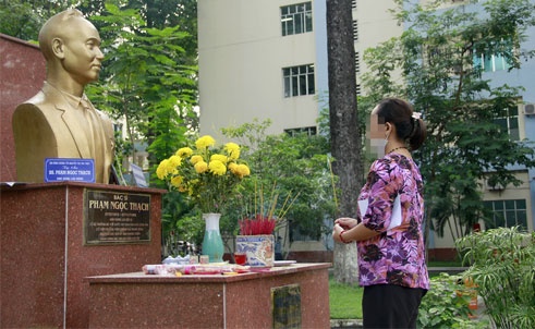 Một người nhà bệnh nhân thắp hương trước tượng bác sĩ Phạm Ngọc Thạch.