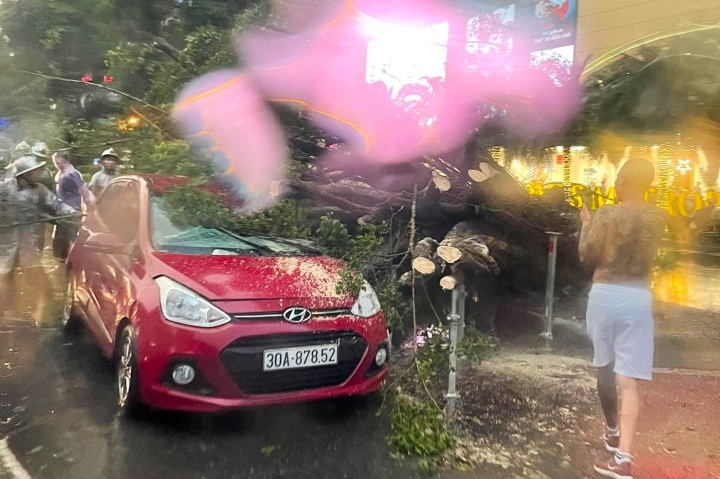 Mua lon, cay do de 2 oto dang di chuyen tren pho o Ha Noi hinh anh