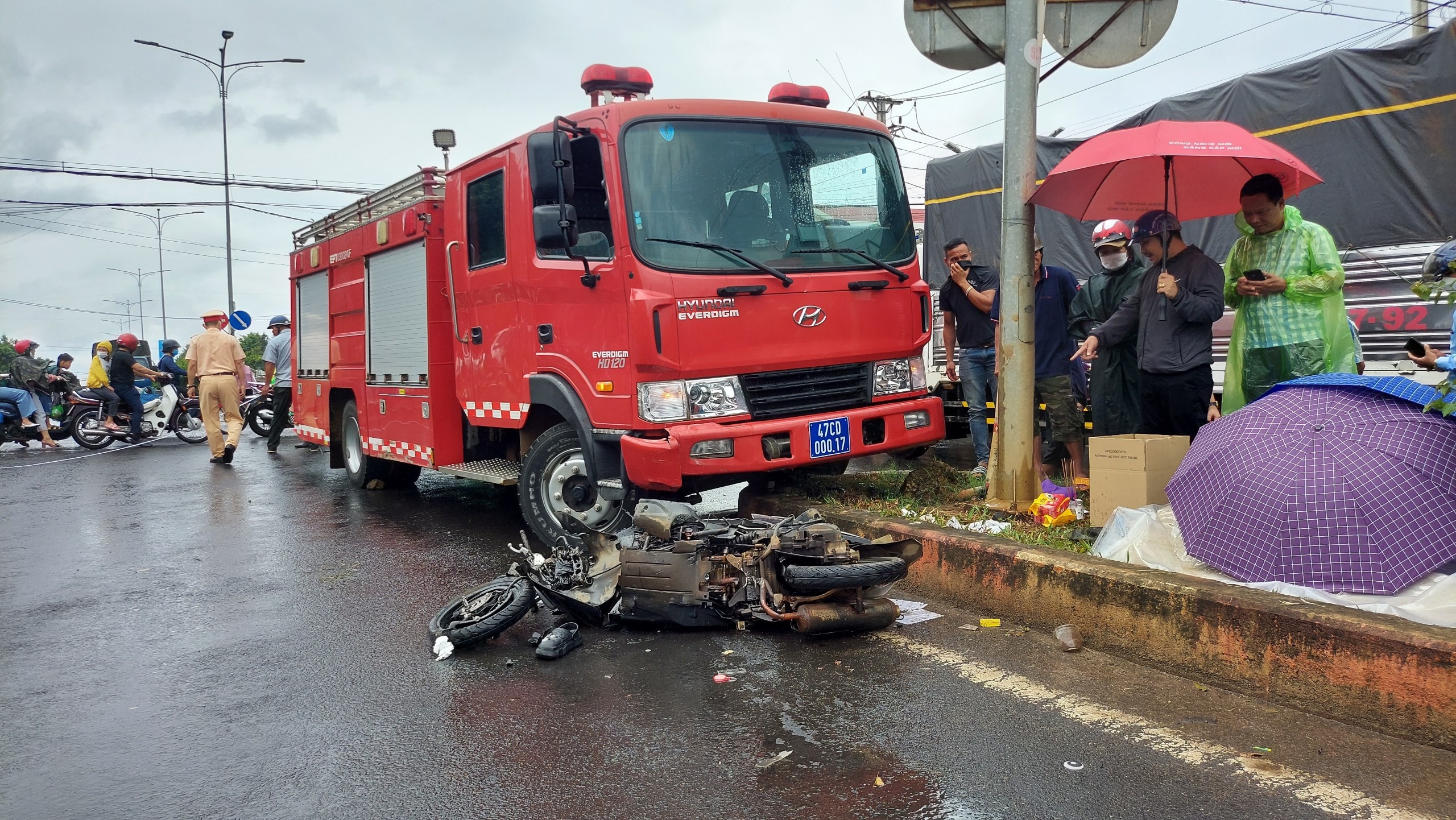 Xe cuu hoa va cham xe may tren duong di chua chay, mot co gai tu vong hinh anh