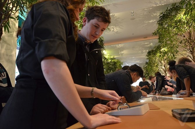 Nhân viên tại cửa hàng bán Apple Watch đang hướng dẫn khách hàng dùng thử sản phẩm.