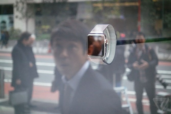 Người dùng đang ngắm nhìn mẫu đồng hồ thông minh Apple Watch qua mặt kính của cửa hàng.