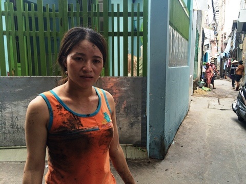 Chị Hồng quần áo lấm lem trong lúc móc cống nước bị tắc tại khu nhà trọ.