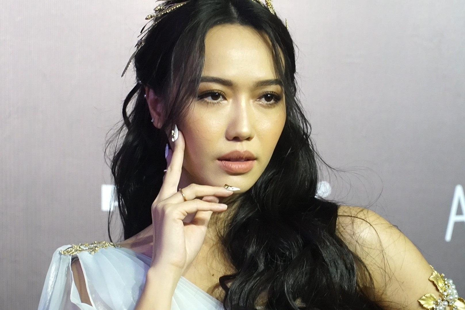 Dieu Nhi roi mong tay gia khi tao dang tren tham do hinh anh