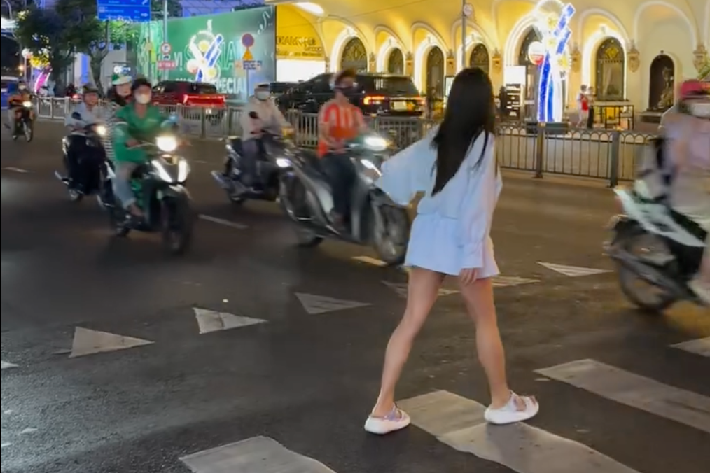 Co gai 'thi pham' cach sang duong o Viet Nam gay bao toan cau hinh anh