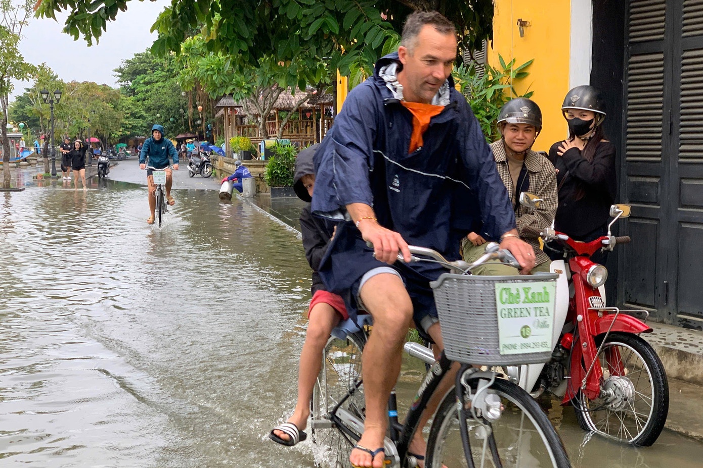 Khach Tay dap xe, loi nuoc lu o Hoi An truoc bao so 12 hinh anh
