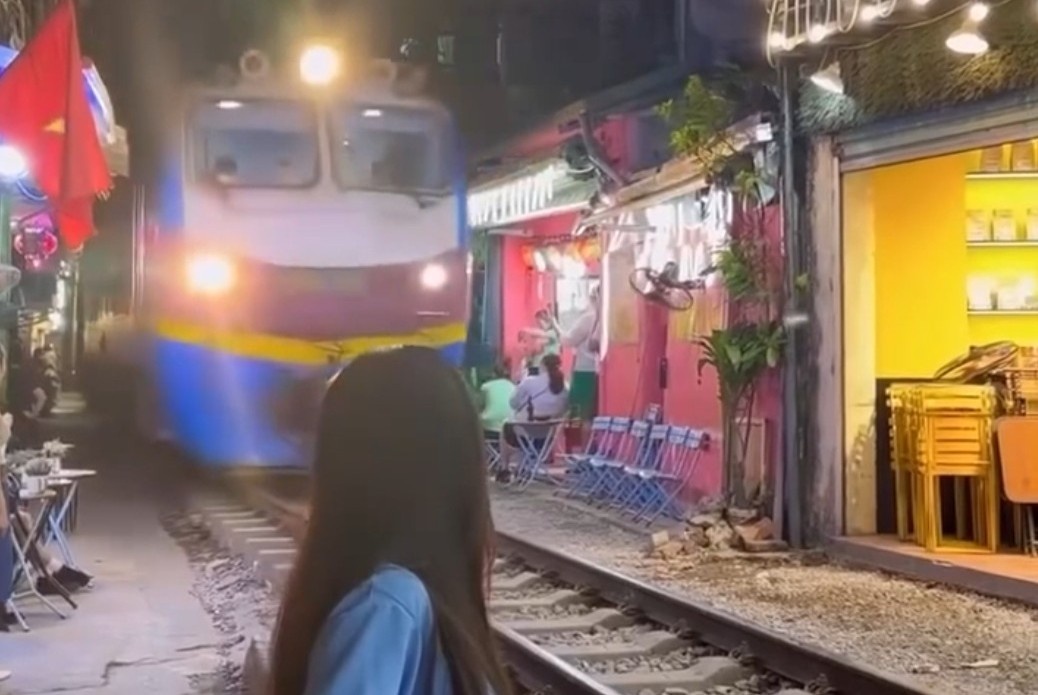 Co gai bat chap ngoi sat duong ray khi tau hoa lao den hinh anh