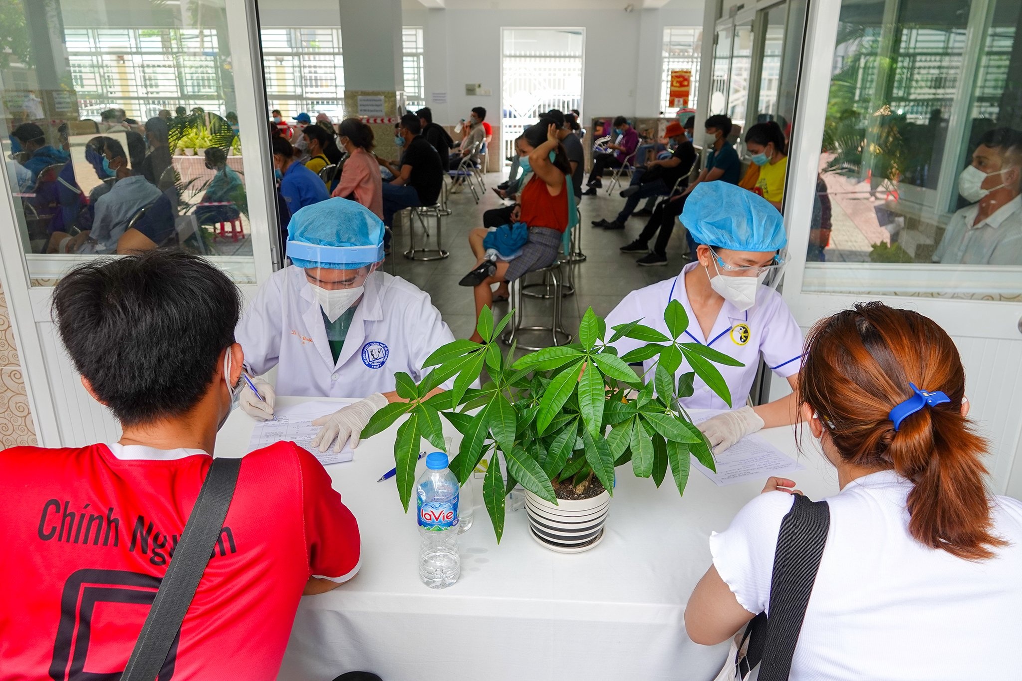 Nguoi lao dong xep hang cho tiem vaccine Covid-19 o TP.HCM hinh anh