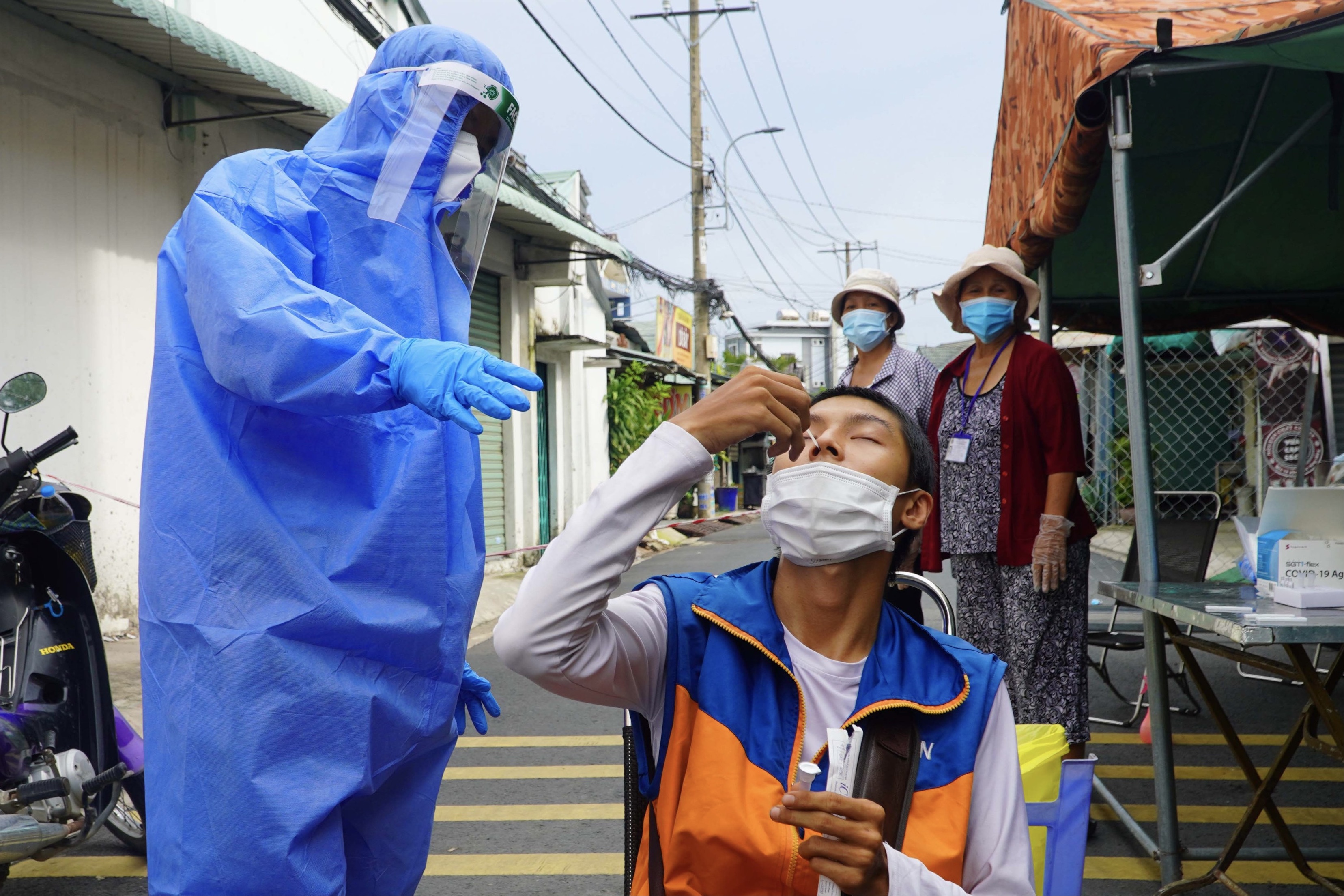 Nguoi dan tu test nhanh Covid-19 tai chot kiem soat o TP.HCM hinh anh