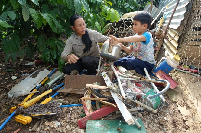 Mẹ con chị Nguyễn Thị Mai phân loại phế liệu trước khi mang đi bán - Ảnh: Mai Vinh