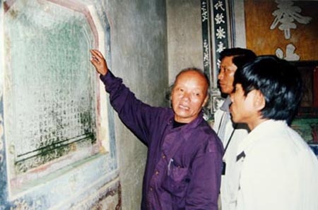 GS Trần Quốc Vượng khảo sát một bia ký ở chùa Quan Thánh làng Lỗ Giáng, phường Hòa Xuân, quận Cẩm Lệ. (Ảnh chụp năm 2003).
