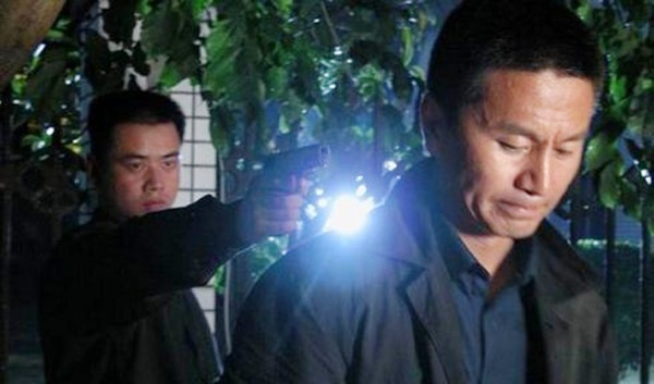 Ngô Nhược Phủ trong một cảnh phim bị chĩa súng vào đầu.