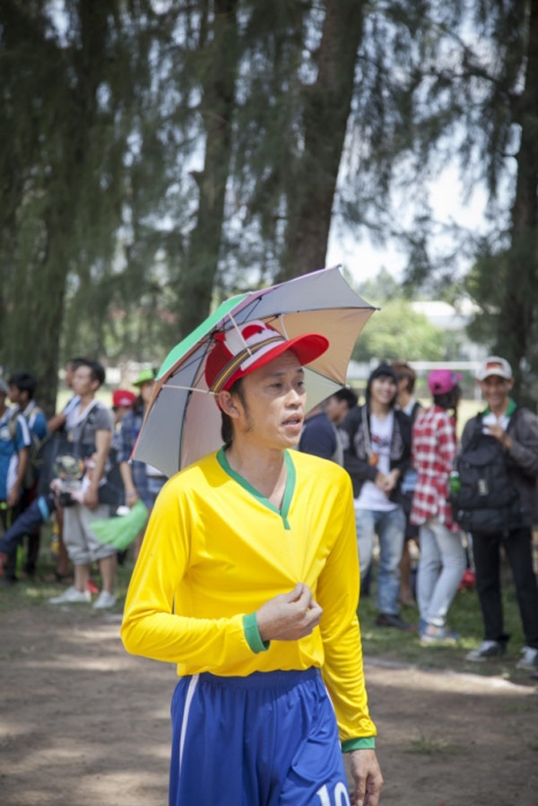 Với chiếc áo	màu vàng rực rỡ cùng chiếc dù trên đầu, anh đã tạo ra hình ảnh vô cùng hài hước.