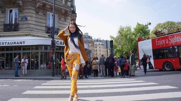 Người đẹp Trúc Diễm thả dáng giữa lòng đường Paris, phía sau cô là chiếc xe buýt chở du khách tham quan thành phố.