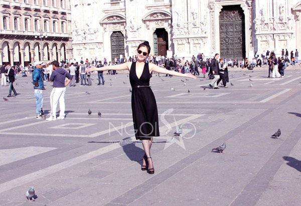 Tại Milan, Ý, Ngọc Trinh tạo dáng ở quảng trường Duomo ngập tràn đàn bồ câu, phía sau là nhà thờ lớn.