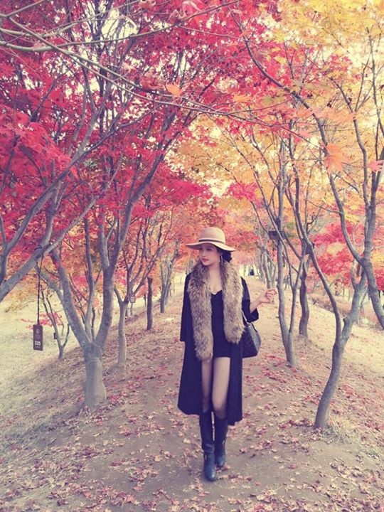 Cựu hot girl kiêm diễn viên Huyền Baby tạo dáng giữa hai hàng cây đang chuyển sang màu lá đỏ.