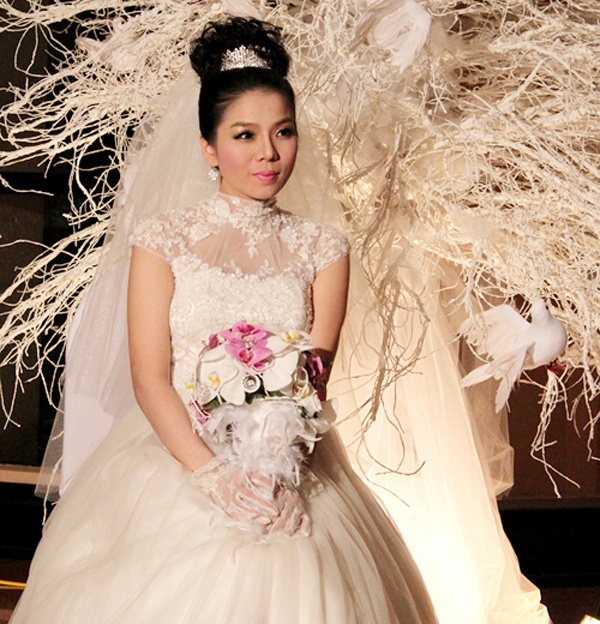 Làm đám cưới khi mang thai ở tháng thứ 6, Lệ Quyên chọn bộ váy cưới chít eo, xòe rộng phù hợp với bụng bầu đã nhô cao. Ngoài váy cưới, giọng ca xinh đẹp còn luôn giữ bó hoa cầm tay trước bụng để giấu bụng. 