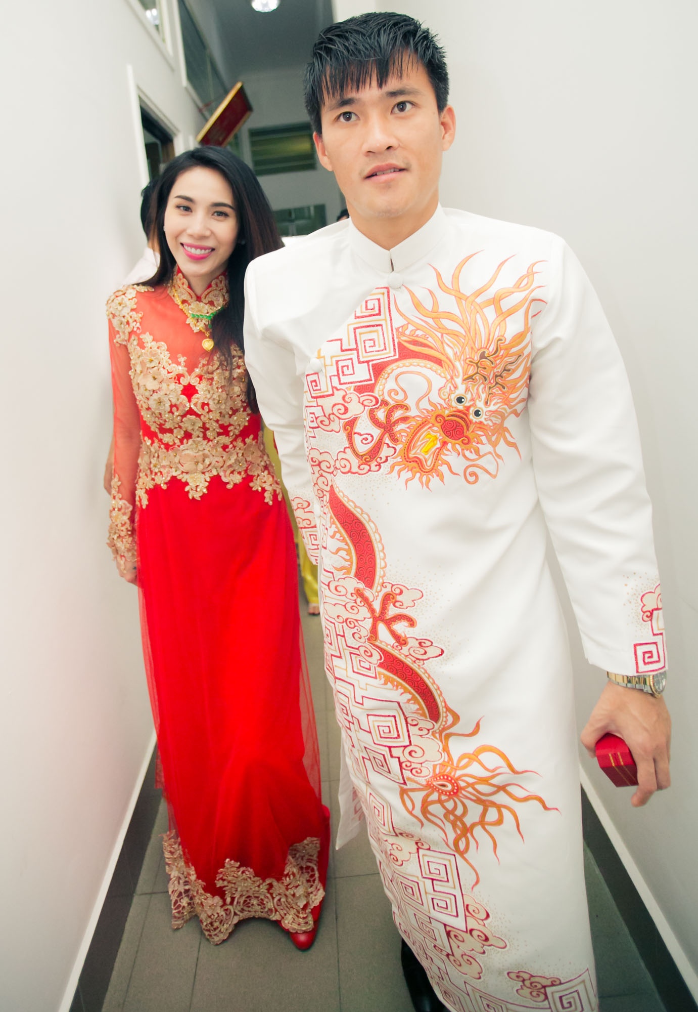 Cầu thủ mang áo số 9 bảnh bao trong trang phục áo dài truyền thống, nắm tay cô dâu ra xe riêng. Chiếc áo dài màu trắng của Công Vinh có hoa văn rồng đỏ đồng điệu với sắc áo của cô dâu.