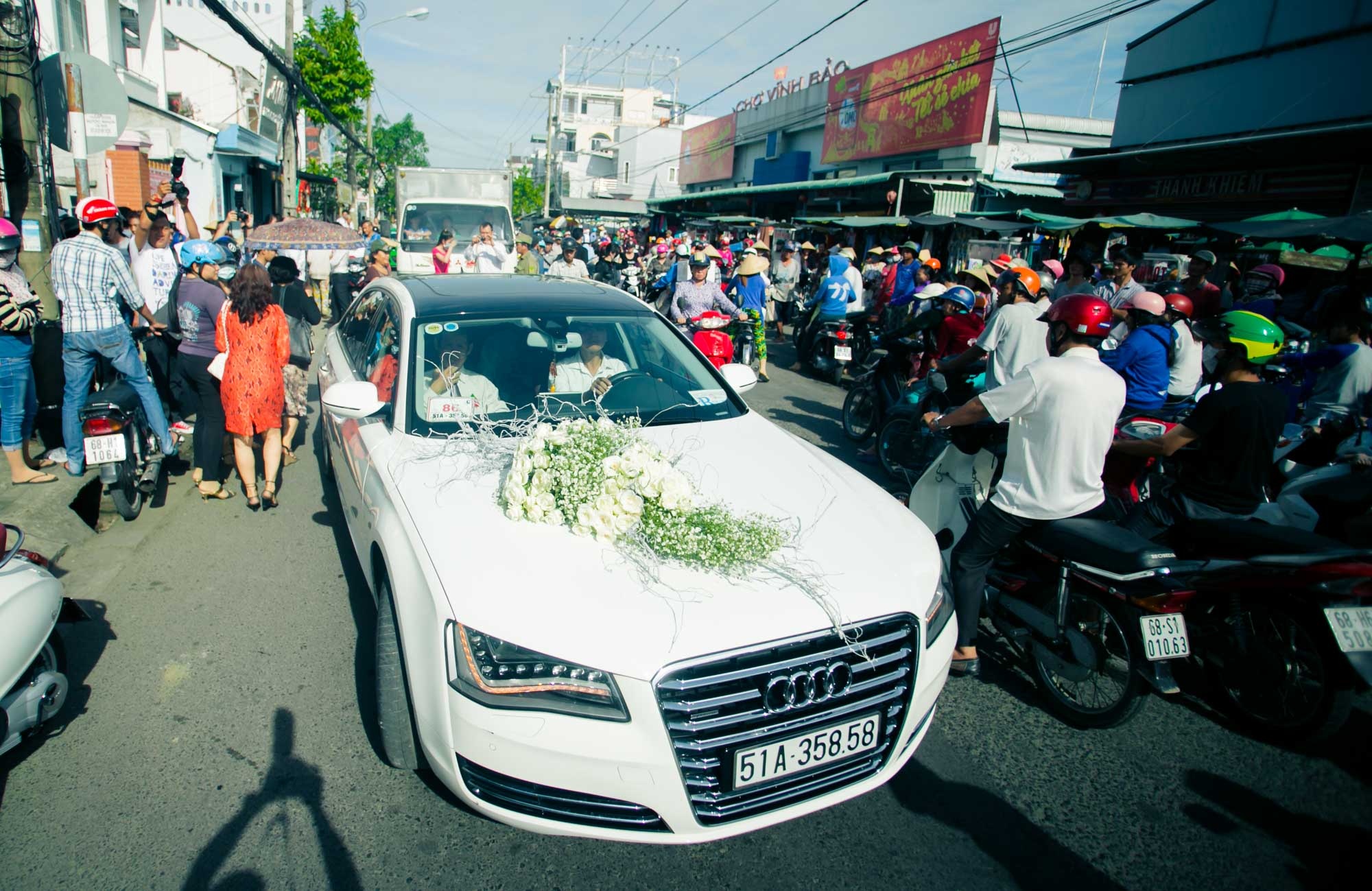 Cặp đôi đang tiến về ngôi chùa trong thành phố làm lễ hằng thuận, trong khi đó, đọn đường nhà cô dâu hàng trăm người rất đông đúc.