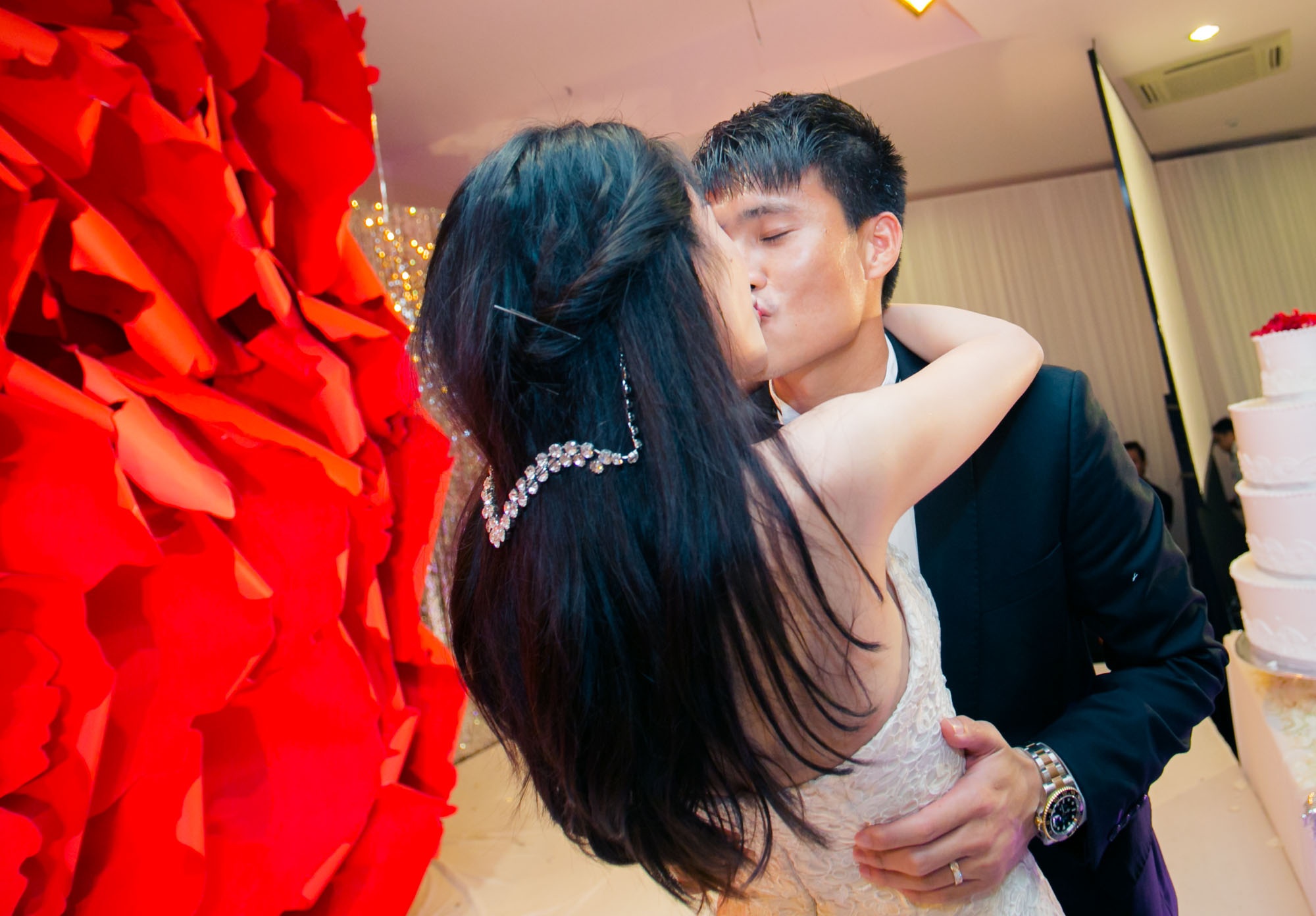 Hai vợ chồng hôn nhau trong tiếng reo hò, cổ vũ của bạn bè.