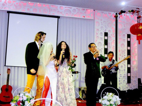 Không mặc váy cưới lộng lẫy như truyền thống, cô dâu Mai Khôi chỉ đội khăn voan, diện áo dài cưới trắng cúp ngực cùng với chiếc quần cam nổi bật. Trong khi đó, chú rể Benjamin cũng phá cách với áo vest và quần vàng. Bữa tiệc được tổ chức trong không khí vui vẻ đầm ấm với sự tham gia của gia đình, bạn bè Mai Khôi và Benjamin.