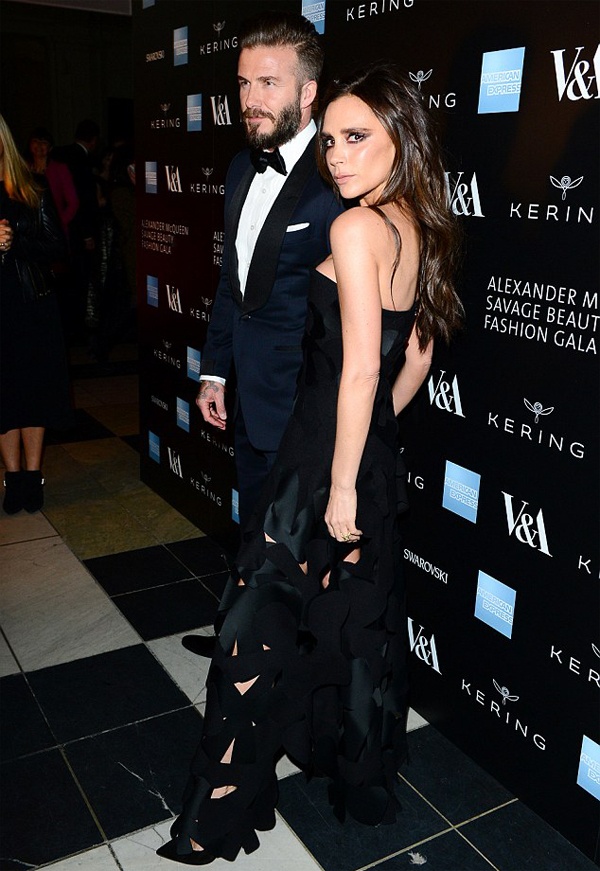 Cặp đôi quyền lực diện trang phục tối màu ăn ý. Beckham mặc bộ suit màu xanh navy, thắt nơ lịch sự. Còn bà xã anh diện bộ váy nằm trong BST mới của cô. Nhiều ống kính hướng về bộ đầm cúp ngực táo bạo và những vết cắt xẻ ở thân váy. 