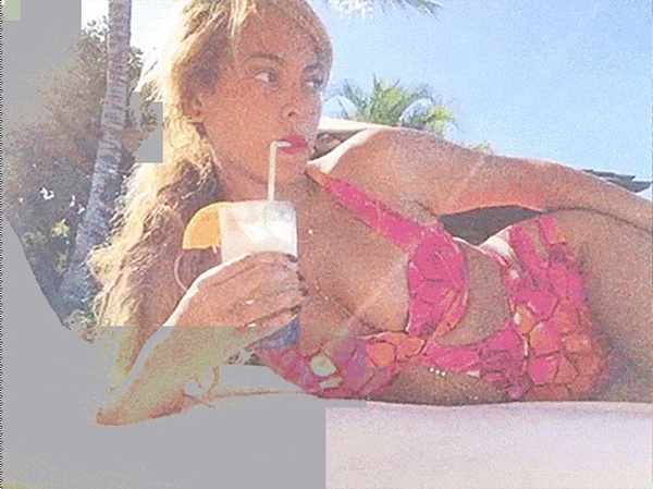 Giọng ca Bootylicious nằm phơi nắng trong bộ bikini hai mảnh màu hồng, để kiểu tóc buộc lệch trẻ trung.