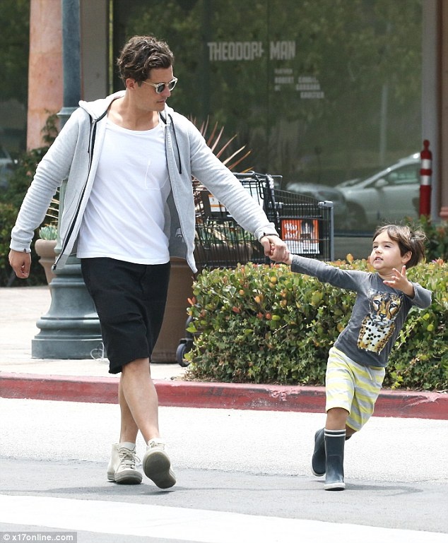 Hai bố con Orlando Bloom ăn vận thoải mái, riêng bé Flynn tỏ ra khá hào hứng, liên tục líu lo. Cậu bé hiếu động nên nam diễn viên 38 tuổi phải giữ tay kéo lại.