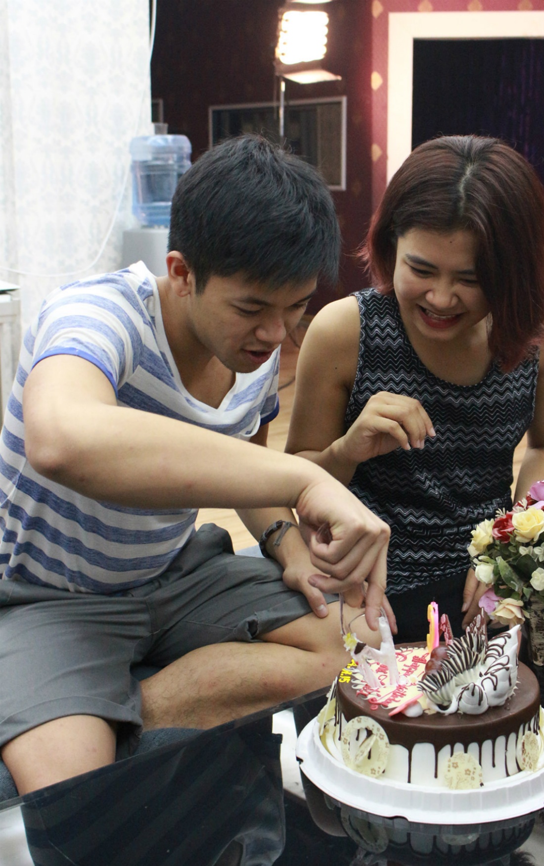 Trọng Hiếu chăm chú cắt chiếc bánh kem theo sự hướng dẫn của Hà Nhi. Thời gian gần đây, cả hai dính tin đồn tình cảm khi thường xuyên chụp ảnh chung hay có những cử chỉ thể hiện sự quan tâm lẫn nhau.